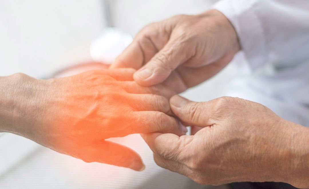 A healthcare provider examining a patient's hand with a symbolic orange glow around it