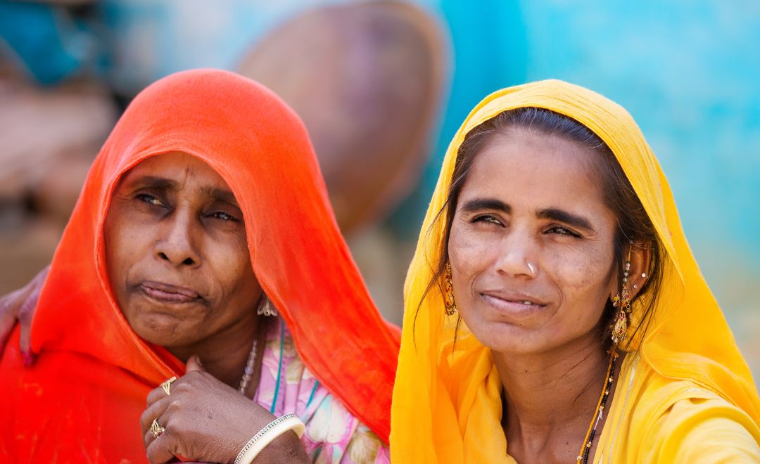 Two women wearing colorful traditional Indian veils