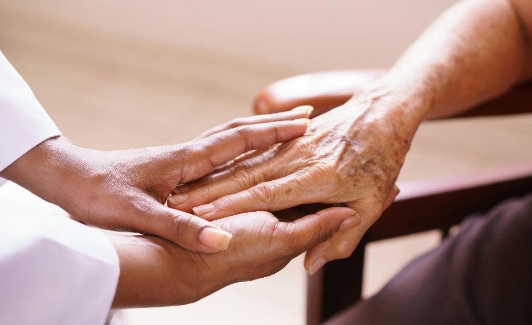 A healthcare provider holding a patient's hand